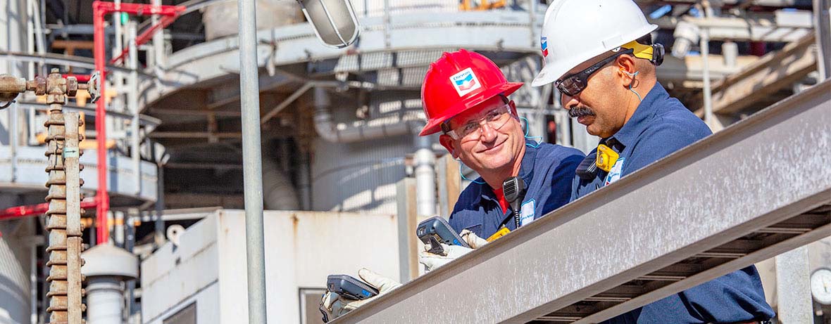 two refinery workers inspecting equipment