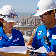 Two Chevron refinery employees sharing a report